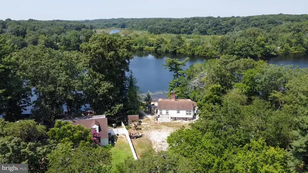an aerial view of a house with a yard and lake view