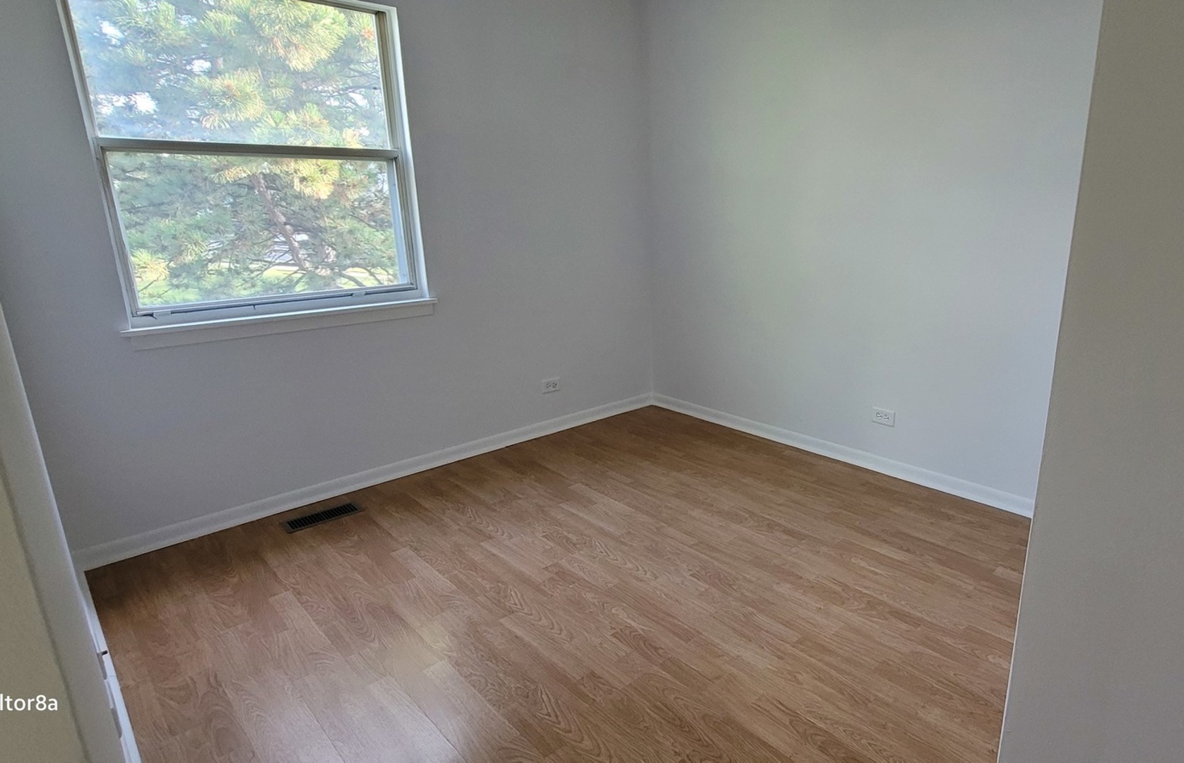 249 Peppertree Lane Aurora, IL 60504 - Photo 3 of 10 an empty room with wooden floor and windows