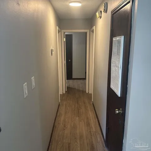 a view of a hallway with wooden floor