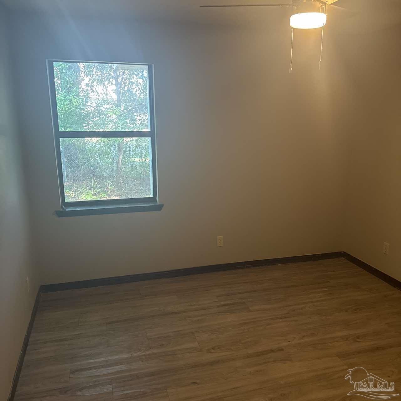 455 Stara Circle, Unit C Pensacola, FL 32505 - Photo 12 of 23 an empty room with wooden floor and windows