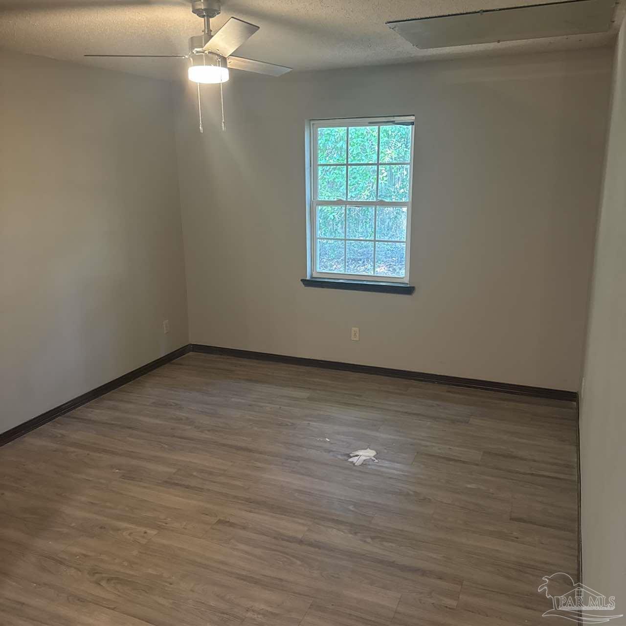 455 Stara Circle, Unit C Pensacola, FL 32505 - Photo 17 of 23 wooden floor in an empty room with a window