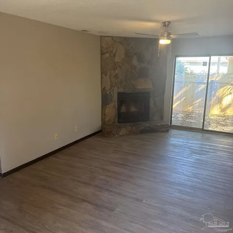 a view of empty room with wooden floor and fireplace