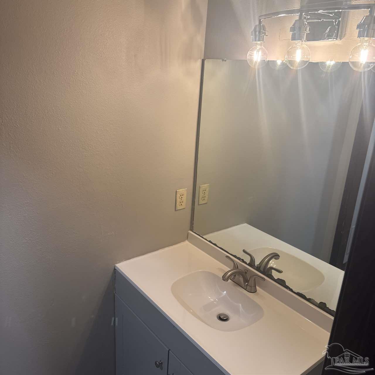 455 Stara Circle, Unit C Pensacola, FL 32505 - Photo 22 of 23 a bathroom with a sink and mirror