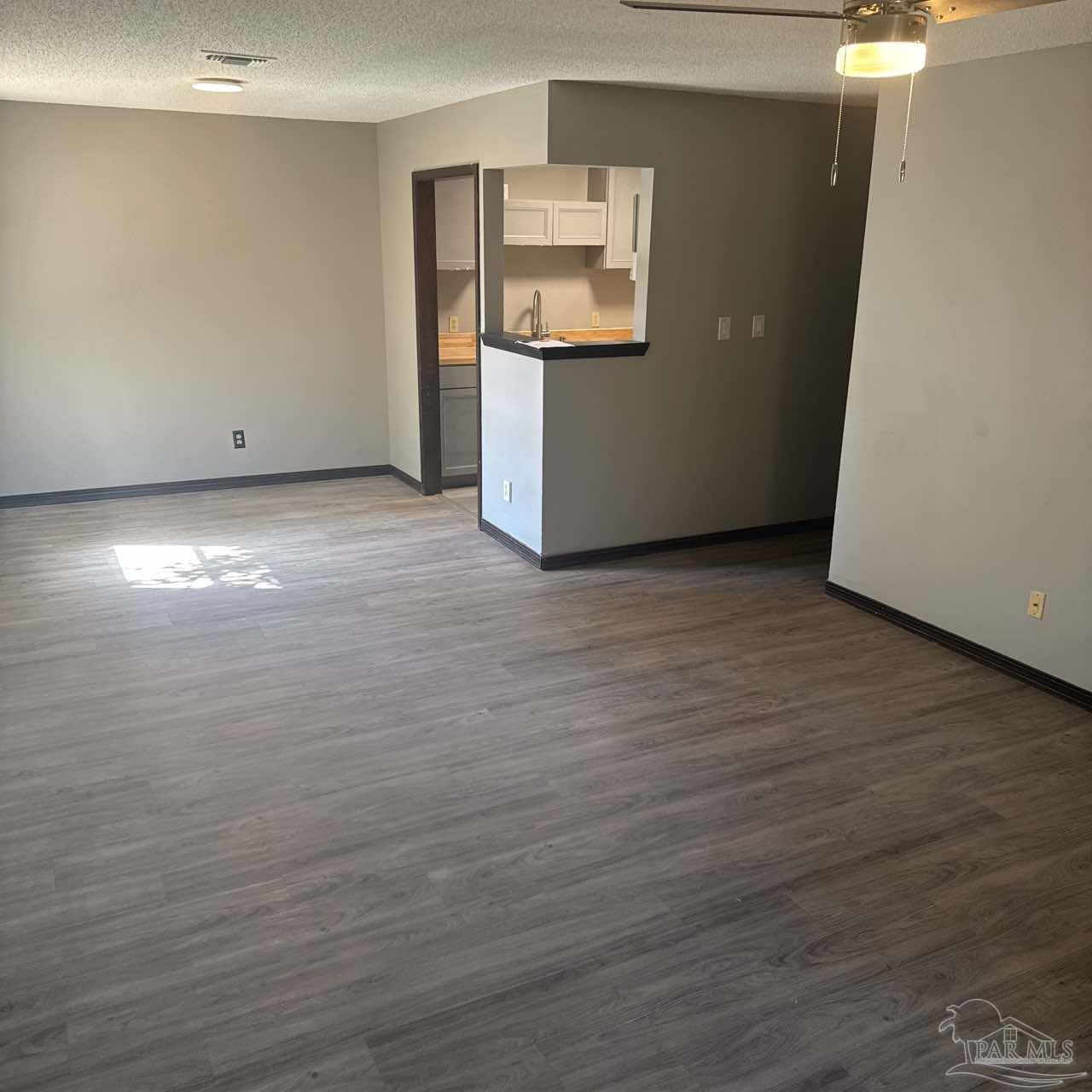 455 Stara Circle, Unit C Pensacola, FL 32505 - Photo 4 of 23 an empty room with wooden floor and windows