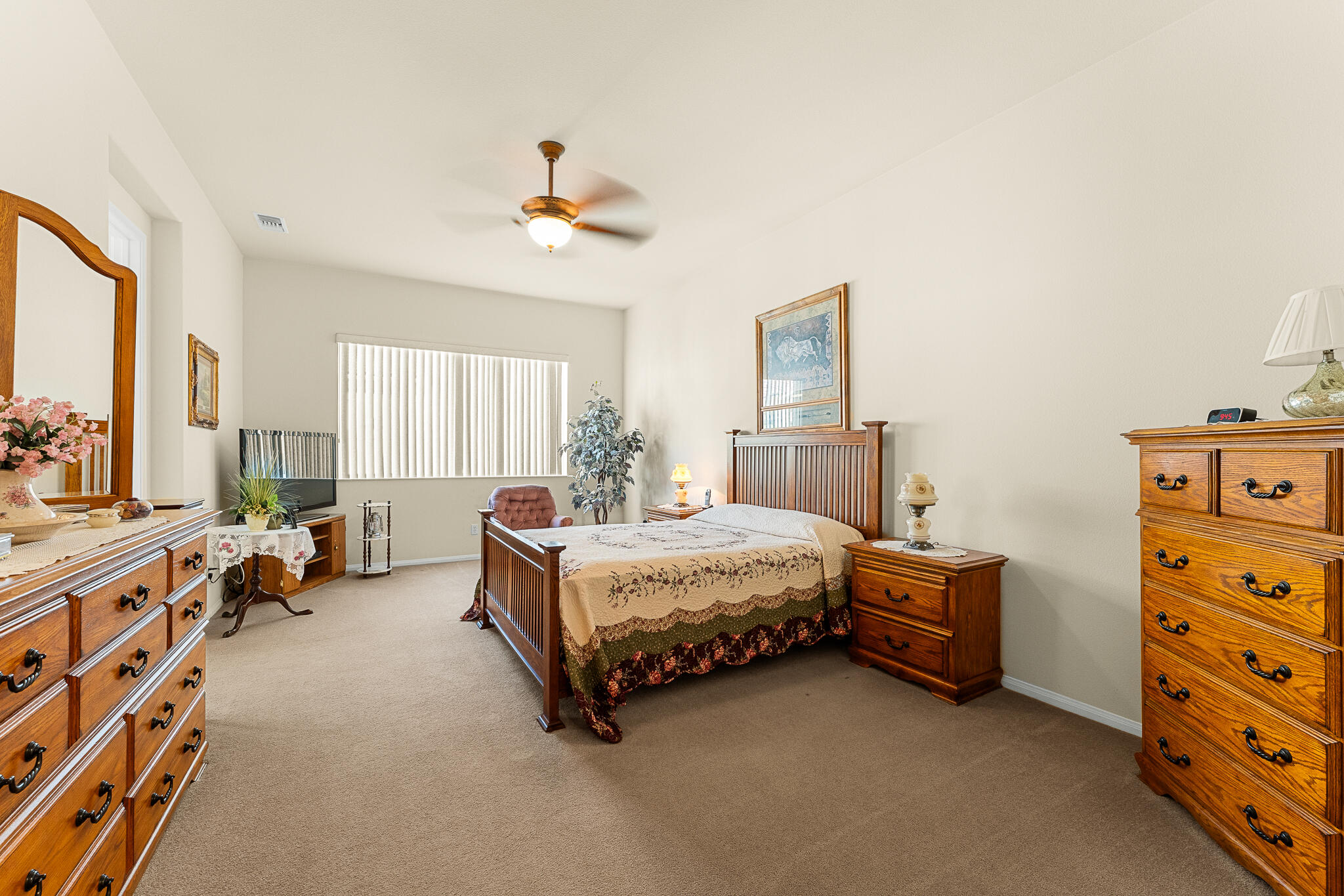 744 Copper Circle Beaumont, CA 92223 - Photo 23 of 44 a spacious bedroom with a bed and a chandelier