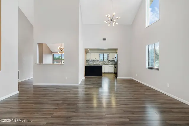 a view of a room with wooden floor and chandelier