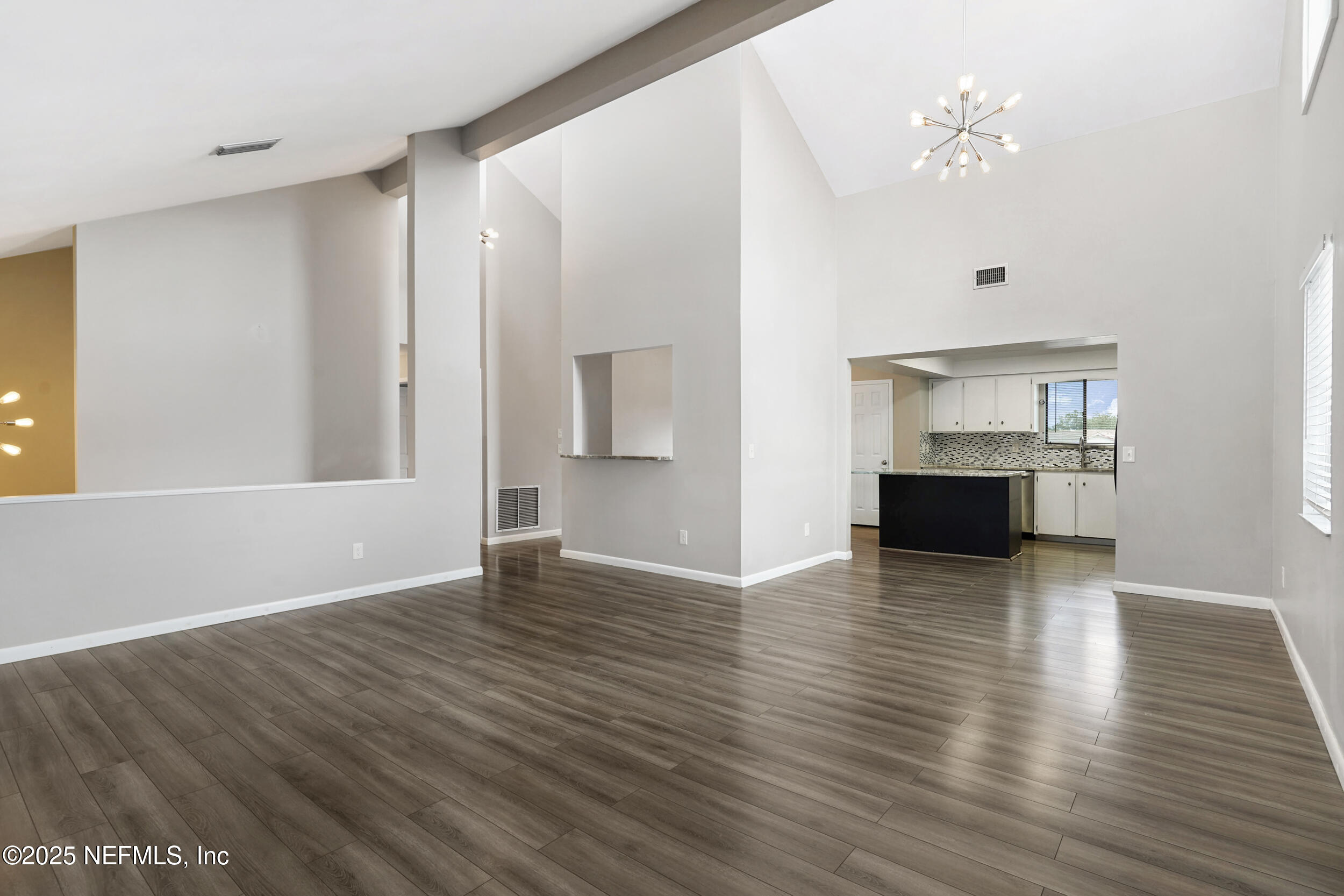 17 Clinton Court South Palm Coast, FL 32137 - Photo 15 of 44 a view of empty room with wooden floor and kitchen view