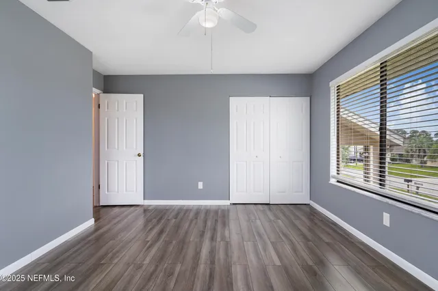 an empty room with wooden floor and windows