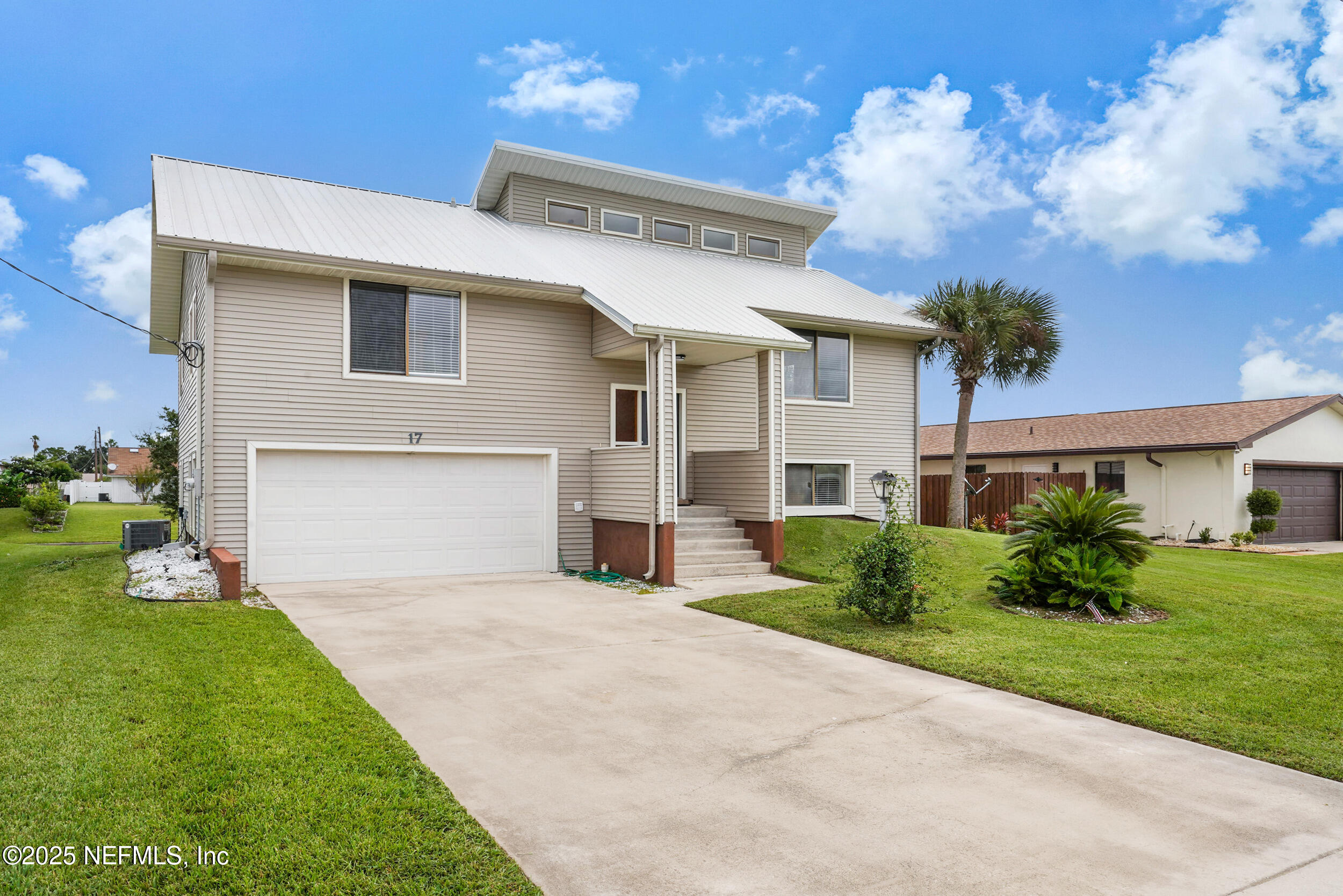 17 Clinton Court South Palm Coast, FL 32137 - Photo 2 of 44 a front view of a house with a garden and garage