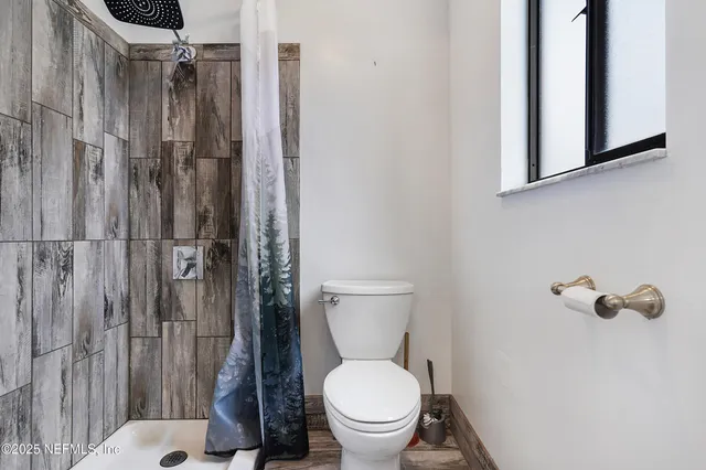 a bathroom with a toilet and a shower