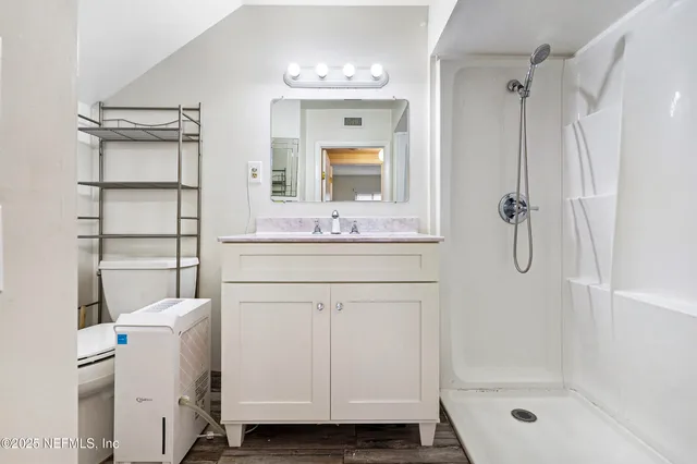 a bathroom with a shower sink vanity and mirror