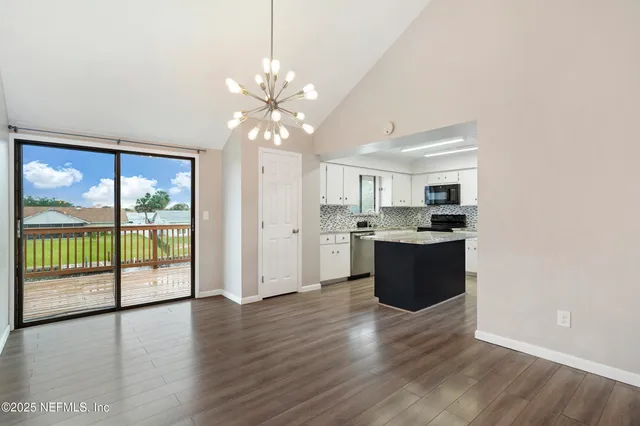 a large kitchen with hardwood floor and a large window