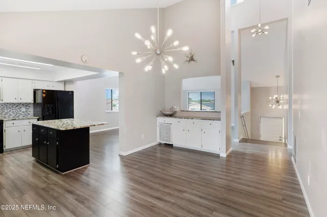 a view of kitchen with granite countertop cabinets and refrigerator