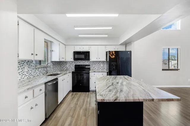 a kitchen with granite countertop kitchen island wooden cabinets and stainless steel appliances