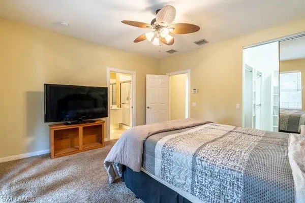 a spacious bedroom with a bed and a flat screen tv