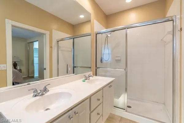 a bathroom with a shower sink and mirror