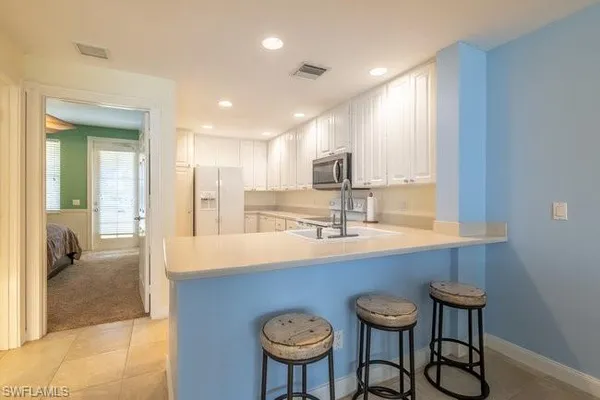 a kitchen with stainless steel appliances a sink a table and chairs in it
