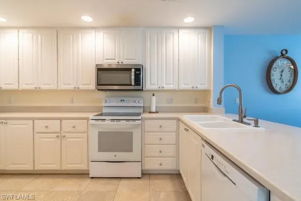 a kitchen with white cabinets stainless steel appliances and sink