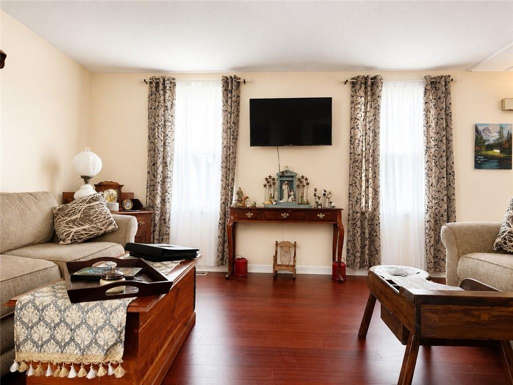 103 Fox Run Road Cranberry Township, PA 16066 - Photo 5 of 24 Rich laminate flooring flows throughout the space, while large windows fill the room with natural light.