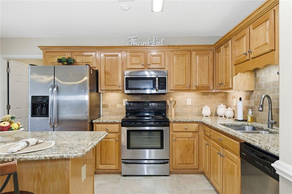 34 Rock Hole Path Dallas, GA 30132 - Photo 14 of 41 a kitchen with kitchen island granite countertop a stove top oven microwave and refrigerator