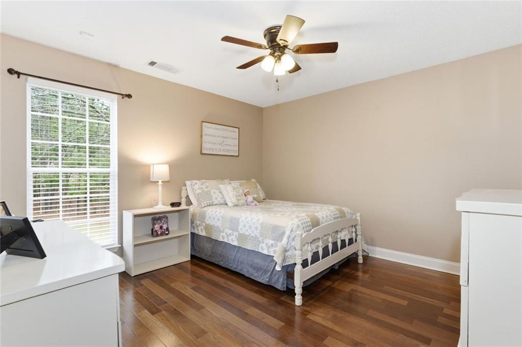 34 Rock Hole Path Dallas, GA 30132 - Photo 20 of 41 a bedroom with a bed and a desk with wooden floor