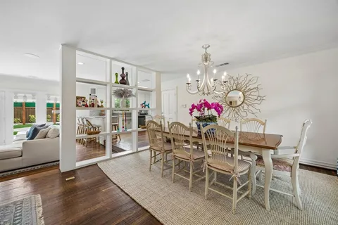 a dining room with furniture a chandelier and wooden floor