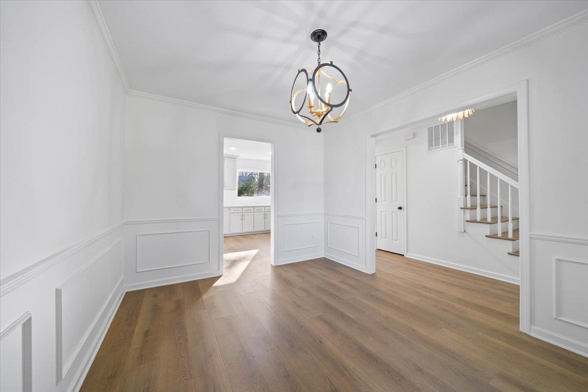 1676 Miller Farms Road Germantown, TN 38138 - Photo 8 of 37 Neutral-toned wood-finish flooring complements crisp white walls with wainscoting and crown molding