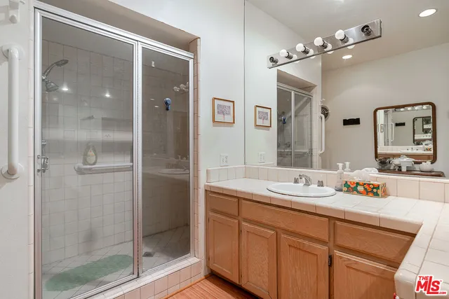 a spacious bathroom with a shower sink mirror and