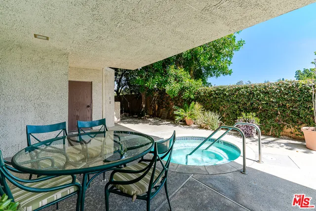 a view of patio with table and chairs and potted plants