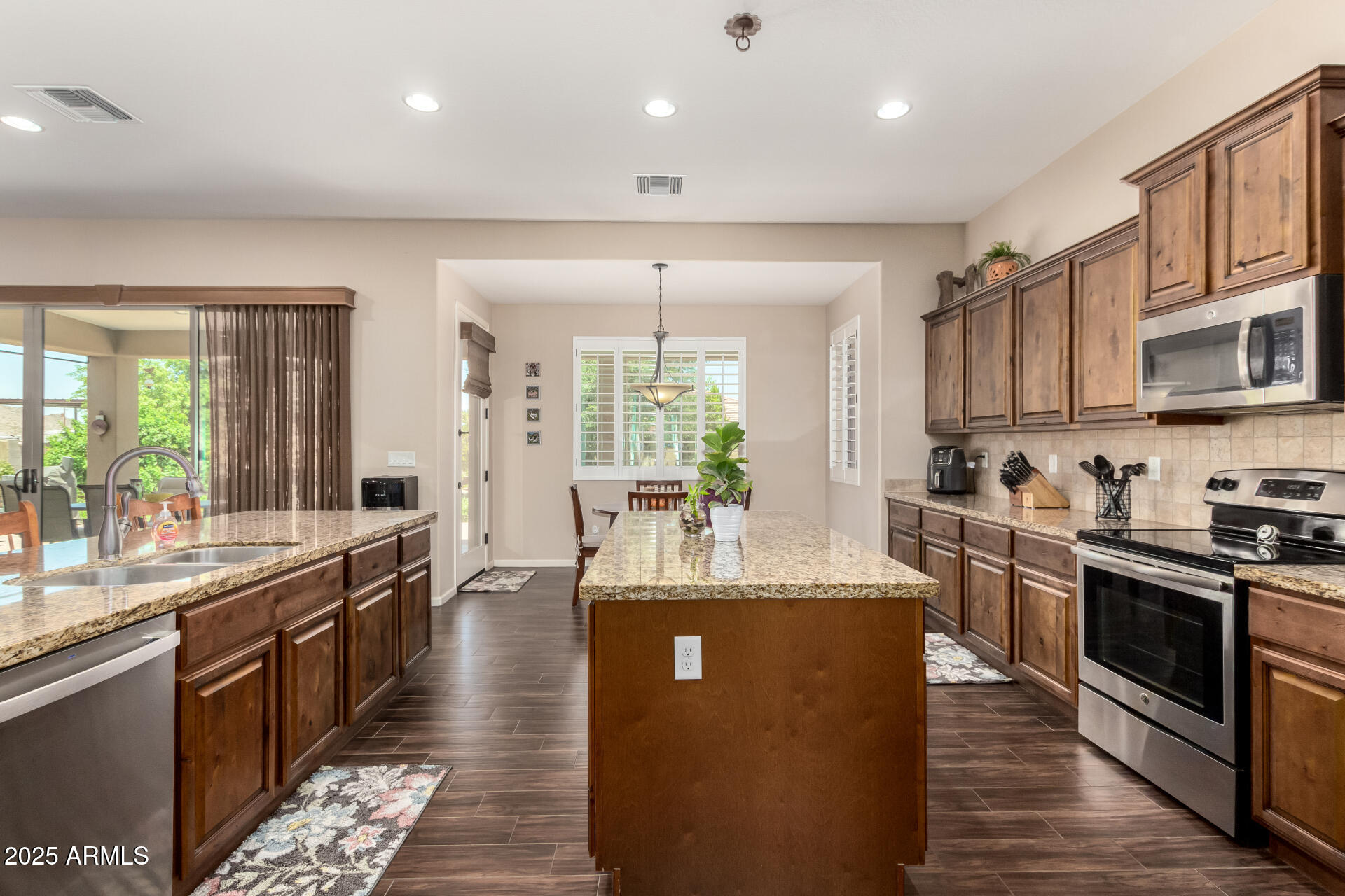 3614 West Phillips Road San Tan Valley, AZ 85144 - Photo 12 of 67 a large kitchen with stainless steel appliances granite countertop a stove refrigerator and cabinets