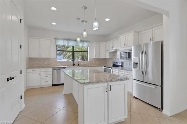 a kitchen with stainless steel appliances granite countertop a refrigerator sink and cabinets