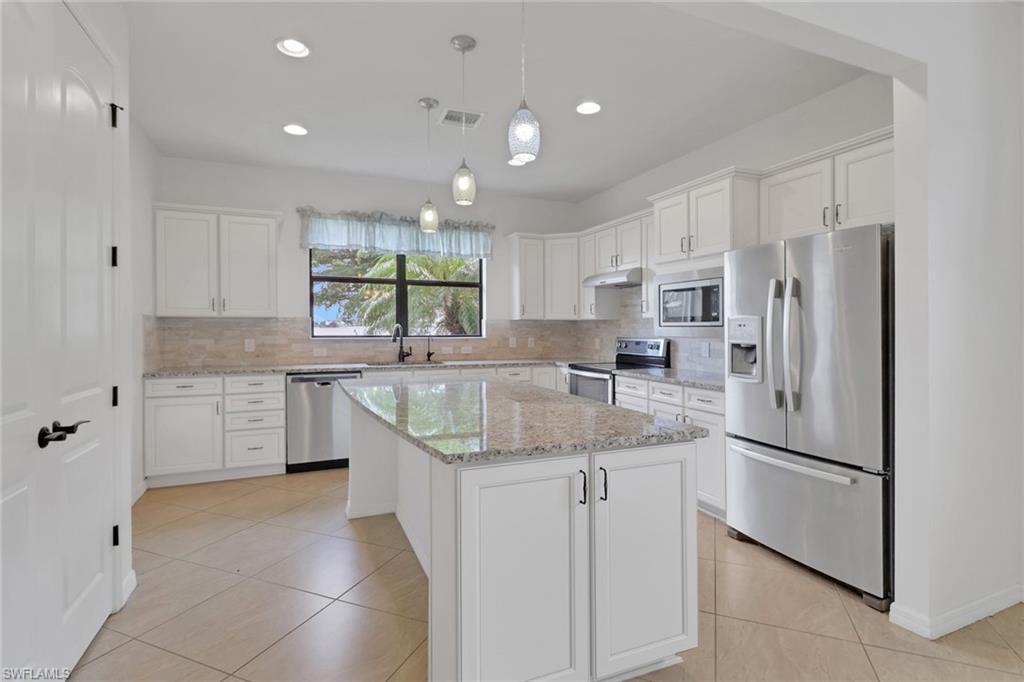 a kitchen with stainless steel appliances granite countertop a refrigerator sink and cabinets
