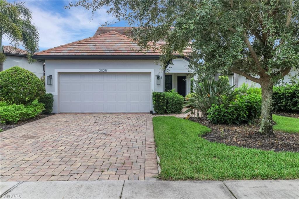 20281 Corkscrew Shores Boulevard Estero, FL 33928 - Photo 2 of 40 a front view of a house with a garden