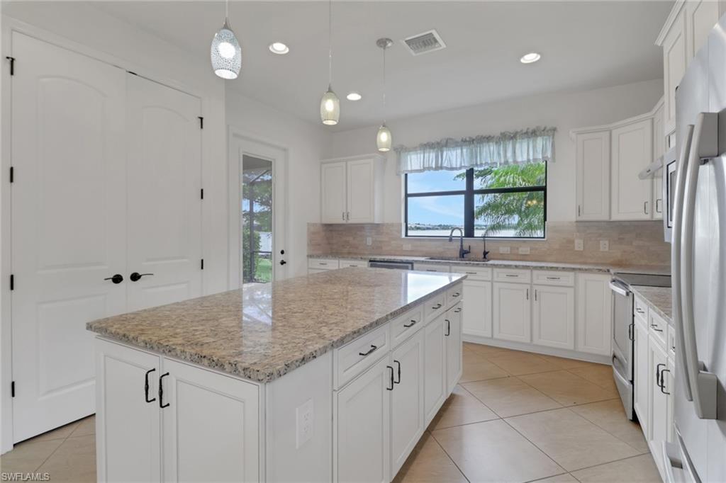 20281 Corkscrew Shores Boulevard Estero, FL 33928 - Photo 8 of 40 a kitchen with granite countertop kitchen island a sink appliances cabinets and a counter space