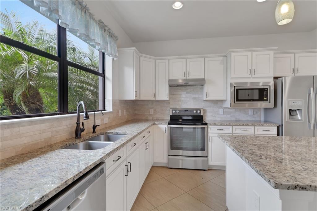 20281 Corkscrew Shores Boulevard Estero, FL 33928 - Photo 9 of 40 a kitchen with granite countertop a sink stainless steel appliances and cabinets
