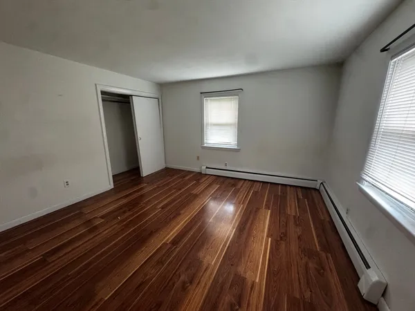 wooden floor in an empty room with a window