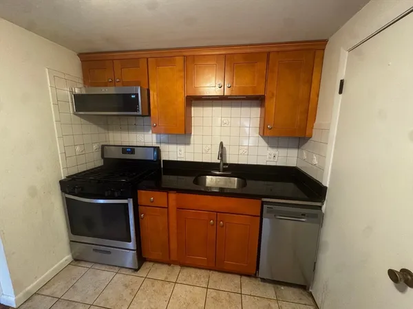 a kitchen with granite countertop a sink and a stove