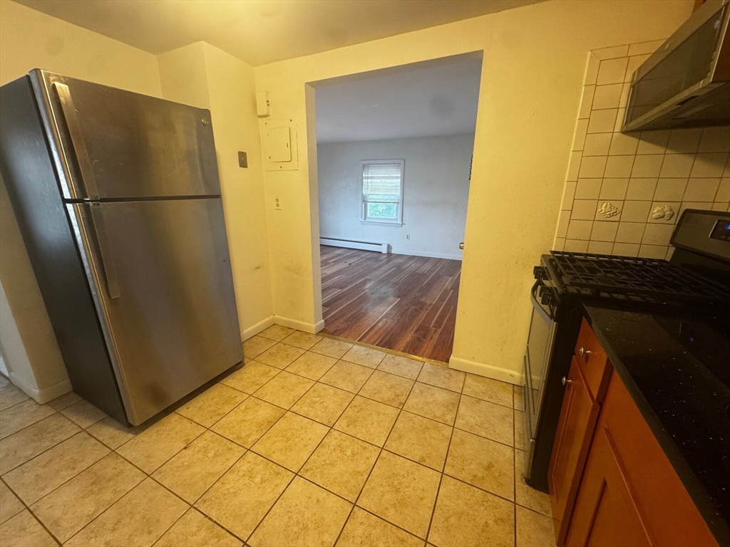 87 R Madison Street, Unit 2R Malden, MA 02148 - Photo 6 of 8 a kitchen with a refrigerator and a stove