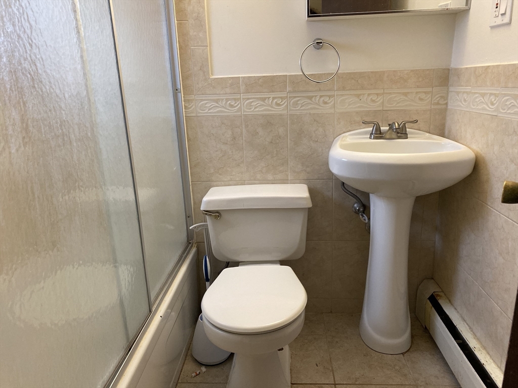 87 R Madison Street, Unit 2R Malden, MA 02148 - Photo 7 of 8 a bathroom with a sink toilet and a mirror