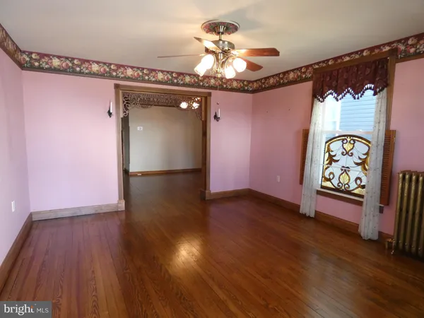 a view of an empty room with wooden floor