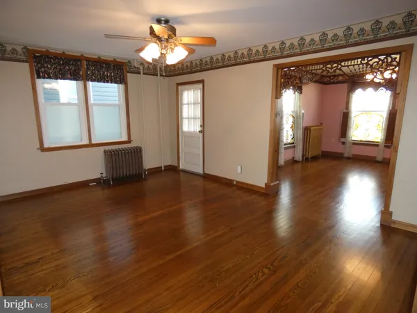 a view of a room with wooden floor and windows
