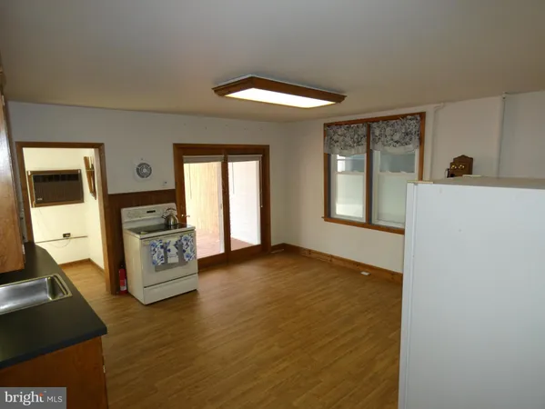 a view of a kitchen with fridge and wooden floor
