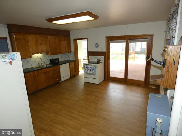 a view of a kitchen with fridge and wooden floor