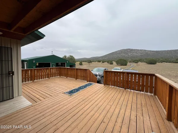 a view of balcony with wooden floor and fence