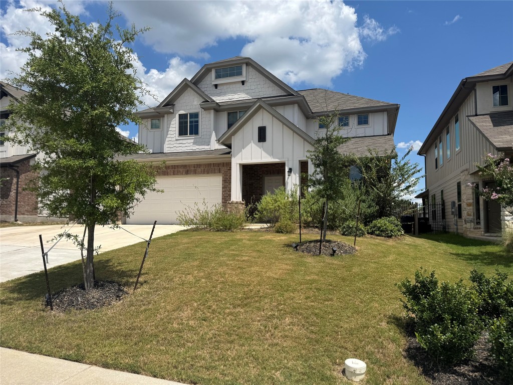 436 Staunton Drive Leander, TX 78641 - Photo 2 of 39 View of front facade with a garage, board and batten siding, brick siding, driveway, and a front lawn