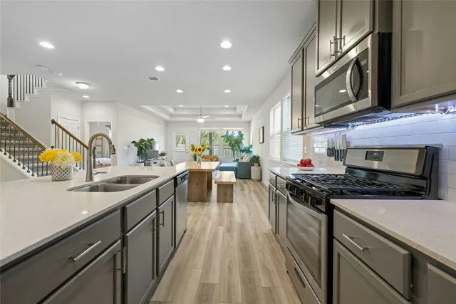 a kitchen with stainless steel appliances granite countertop a sink stove and refrigerator