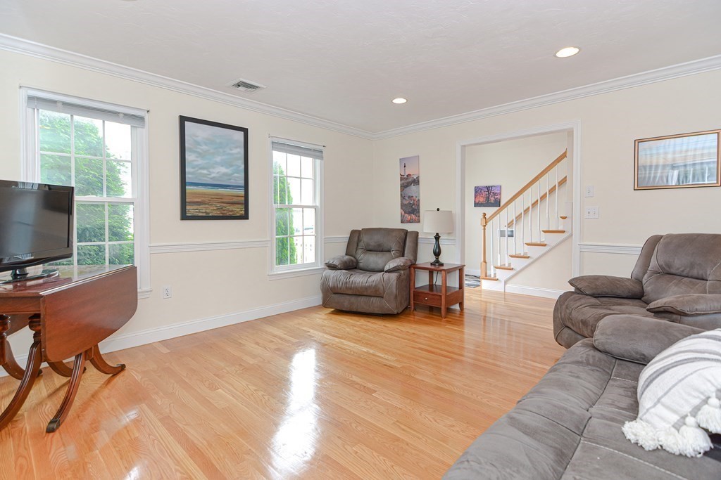 237 Pleasant Street, Unit 237 Norwood, MA 02062 - Photo 12 of 40 a living room with furniture and a flat screen tv