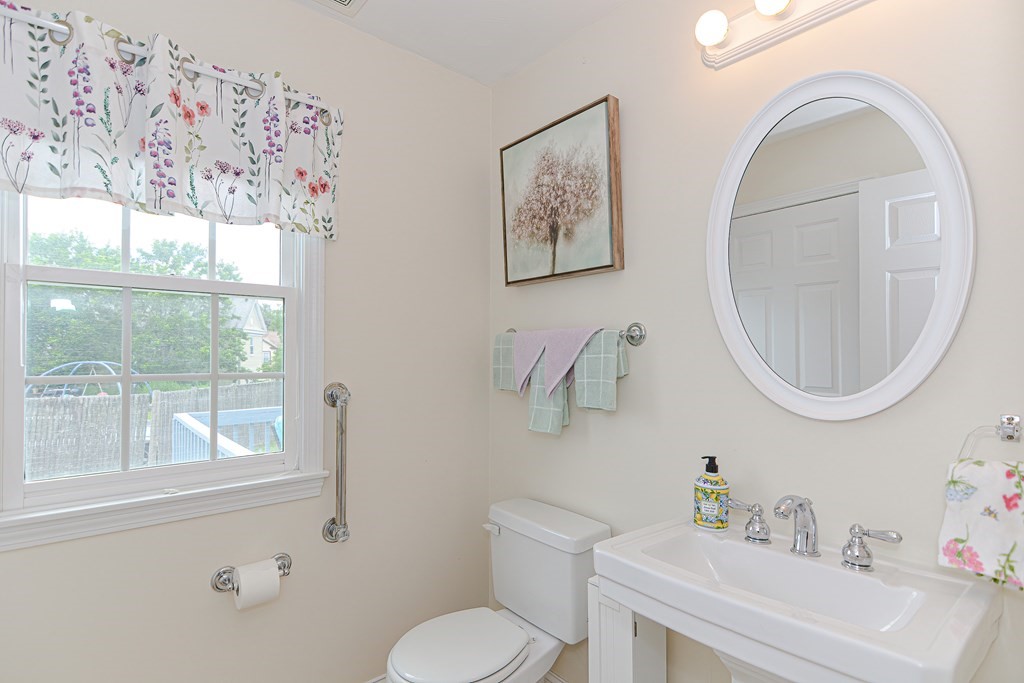 237 Pleasant Street, Unit 237 Norwood, MA 02062 - Photo 14 of 40 a bathroom with a toilet a sink and a mirror