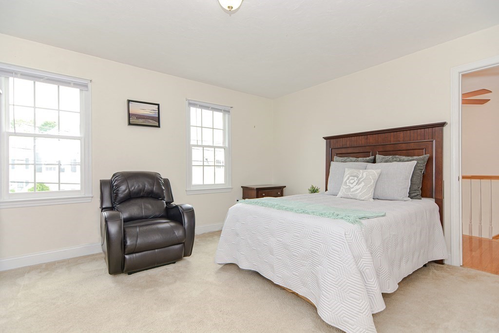 237 Pleasant Street, Unit 237 Norwood, MA 02062 - Photo 17 of 40 a bedroom with a bed and wooden floor