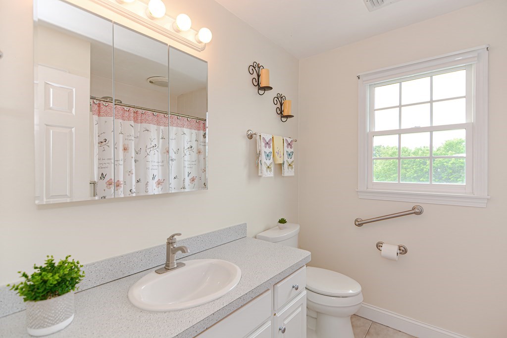 237 Pleasant Street, Unit 237 Norwood, MA 02062 - Photo 20 of 40 a bathroom with a sink toilet and a mirror